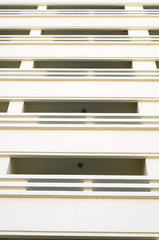 rows of many white balconies of a modern building