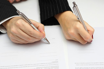 man and woman signing document or prenup