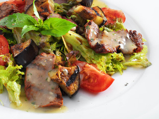 Delicious healthy warm salad with beef and vegetables on a round