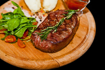 Grilled steak with potatoes, salad and ketchup