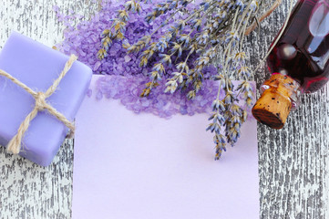 Lavender flower, soap, salt and blank paper on a wooden