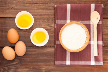 Eggs, milk and flour on a wooden table