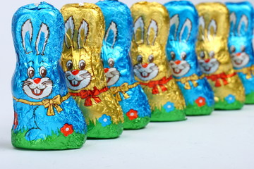 Schokoosterhasen stehen versetzt hintereinander