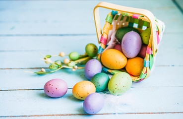 Fototapeta na wymiar Easter eggs in the basket on blue wooden background