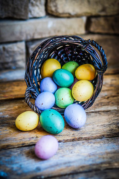 Easter eggs in the basket on rustic wooden background