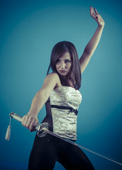 Beautiful brunette girl with Katana in studio