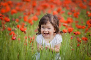 very happy child girl in poppy field