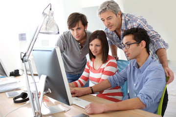 Teacher with students working on desktop