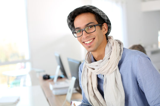 Portrait of smiling student with hat and eyeglasses