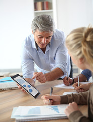 Teacher in classroom using tablet with students