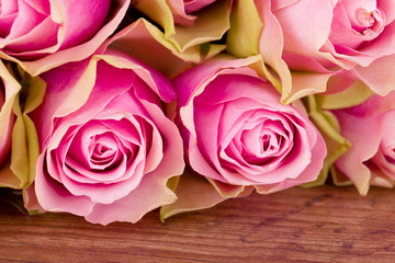 pink roses on brown wooden table