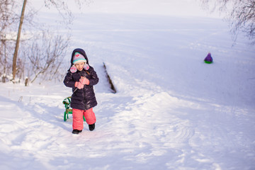Fototapeta na wymiar Little adorable happy girl enjoying snow sunny winter day