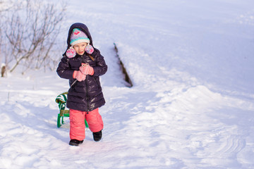 Fototapeta na wymiar Little adorable happy girl enjoying snow sunny winter day