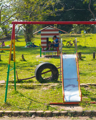 Fototapeta na wymiar Slide and swings in a children's playground