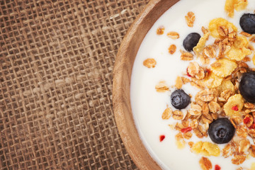 Top view of muesli with yogurt and fresh blueberries. background
