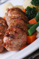 Grilled sausage with vegetables macro. Vertical