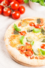 italian pizza on tablecloth with tomatoes