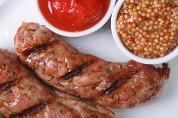 two grilled hot sausages with ketchup and Dijon mustard