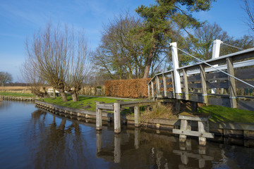 Fototapeta na wymiar Wooden bridge over a canal in winter