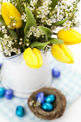 Fototapeta na wymiar Easter setting with yellow tulips and chocolate eggs