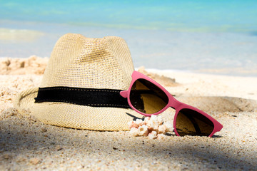 Fototapeta na wymiar Słomkowy kapelusz i okulary na tropikalnej plaży
