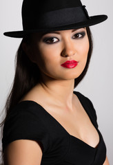 Charming young woman Asian in hat