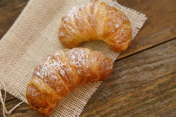 Two croissants on a linen cloth