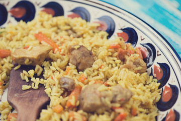 Plov or pilaf in a plate with ornaments, horizontal shot