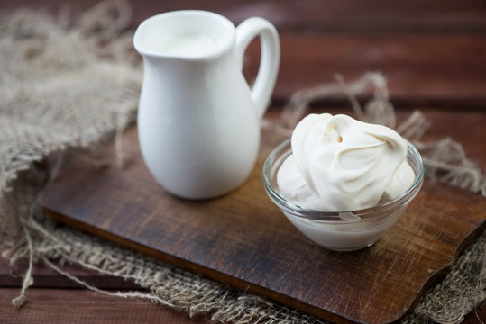 Sour cream over rustic wooden background