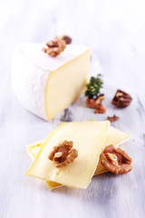 Tasty Camembert cheese with nuts and thyme, on wooden table