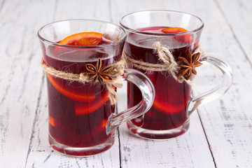 Mulled wine with spices on wooden background