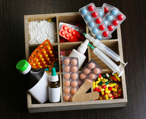 Medical pills, ampules in wooden box, on color wooden