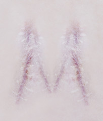 Scar letter M on human skin