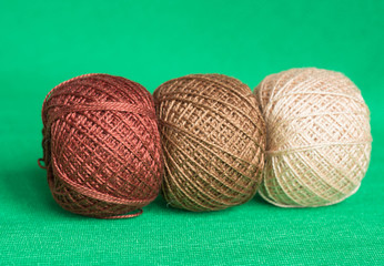 Some balls of a multi-colored yarn on a green background