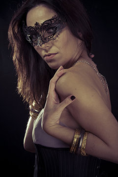 Vintage.Beautiful young woman in mysterious black Venetian mask.