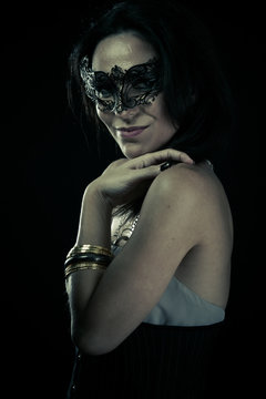 Tribal.Beautiful young woman in mysterious black Venetian mask.