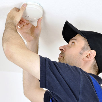 Handwerker montiert Rauchmelder als Feueralarm