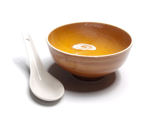 Orange plate and china spoon on white background