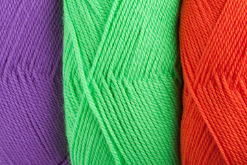 background of yarn skeins in green, orange and purple colors