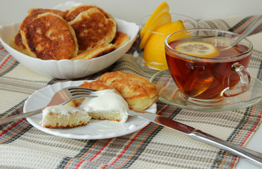 Pancakes with sour cream and a cup of tea for breakfast