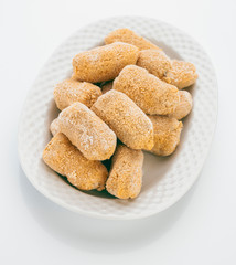 frozen croquettes, before cooking, in white tray