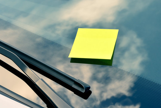 Yellow sticky note on a windshield