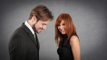 Laughing couple studio portrait against grunge background.