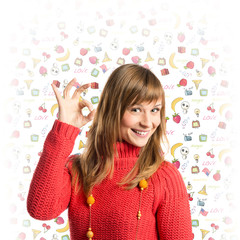 Young woman making Ok sign over white background with icons