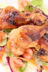 Fried chicken legs with side salad decorated with basil