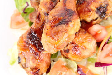 Fried chicken legs with side salad decorated with basil