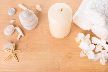 Fototapeta na wymiar Spa still life with orchid, stones, candle burning and towel on