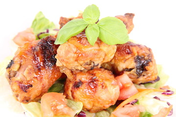 Fried chicken legs with side salad decorated with basil