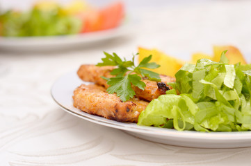 Dish with grilled pork loin, salad and potatoes