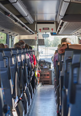 View from inside the bus with passengers. - obrazy, fototapety, plakaty